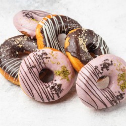 16 delikate donuts fyldt med vaniljecreme, overtrukket med mørk chokoladeovertræk og appelsinglasur fra Delicieux Catering & Takeout
